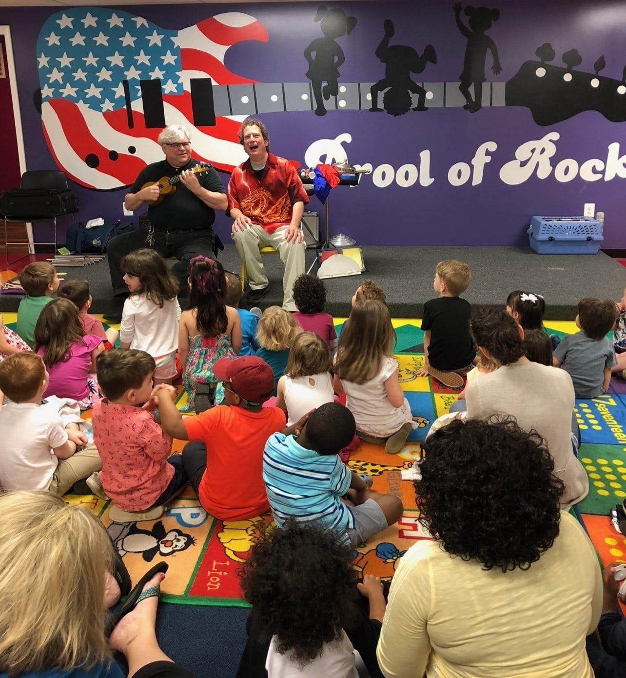 Children sitting in front of two musicians performing on stage. Our expertly designed programs emphasize cognitive, emotional, social, and physical growth through engaging activities and nurturing guidance. Join our enriching community today and empower your child to unlock their full potential, setting the foundation for lifelong learning and success. Enroll today!