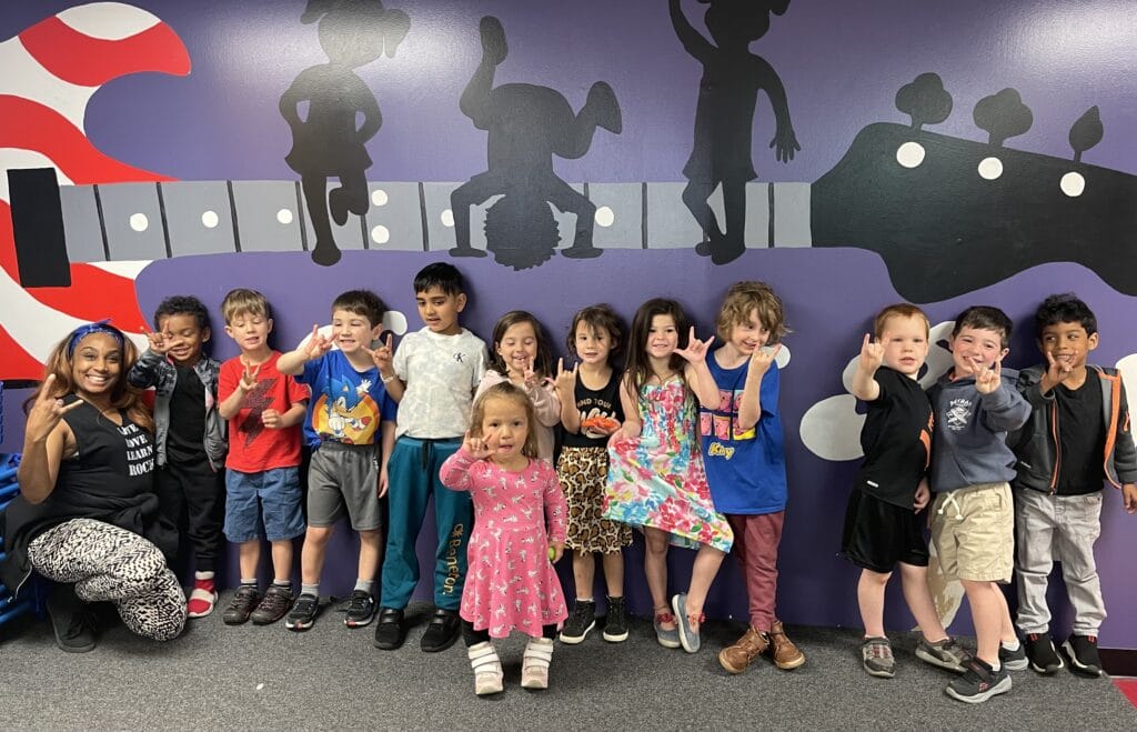 babies taking picture with a rock sign